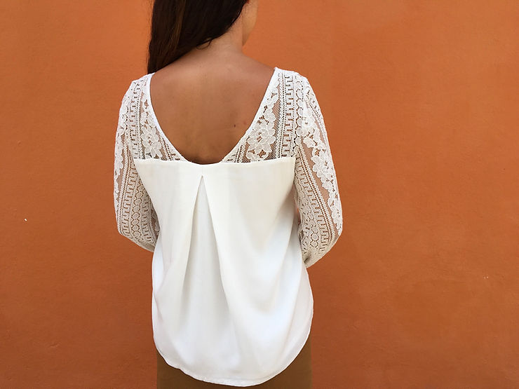 Dos de la blouse blanche cousue main avec décolleté et empiècement en dentelle blanche